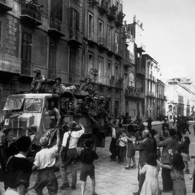 1943:  American troops travelling through Naples in British trucks on their way to the front are given a warm welcome by the Neapolitans.  (Photo by Keystone/Getty Images)